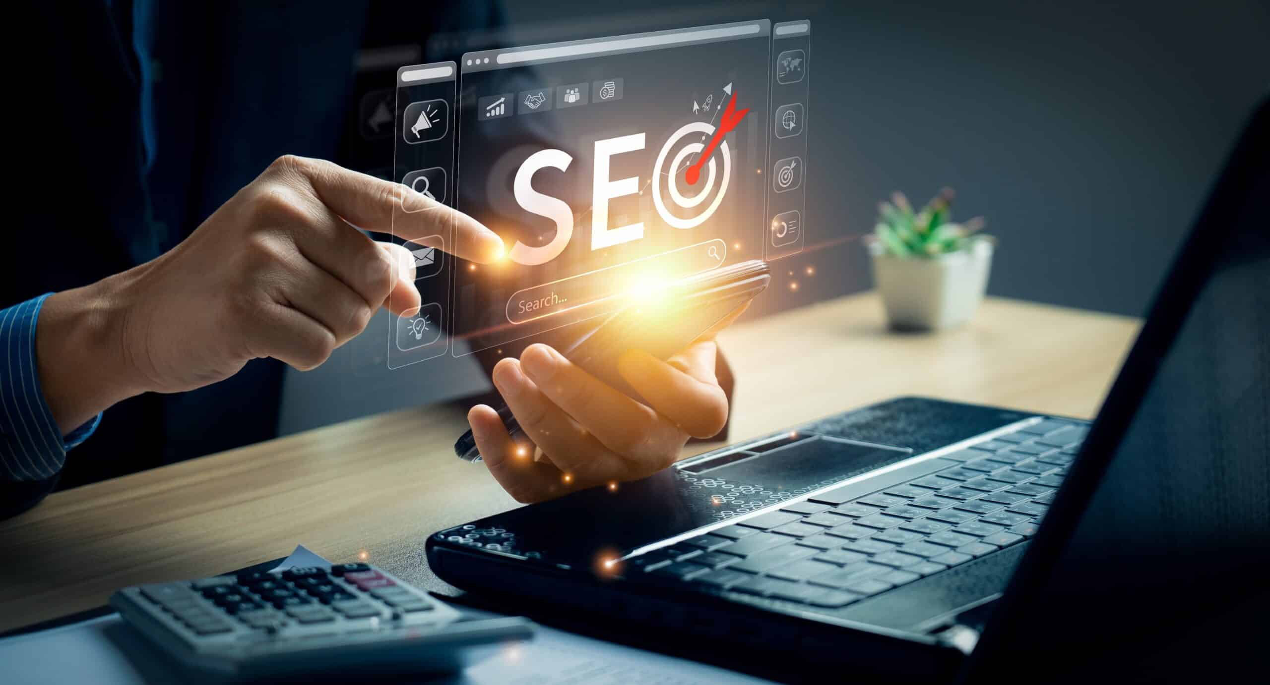 website audit and search engine audit for small businesses image of man holding a cell phone and in background his desk and laptop